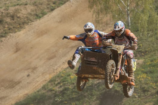 MOHELNICE, CZECH REPUBLIC - APRIL 25.  Gymnastics of racers in jump  in the "International Championship of Czech Republic in sidecarcross 2015"" on April 25. 2015 in Mohelnice."