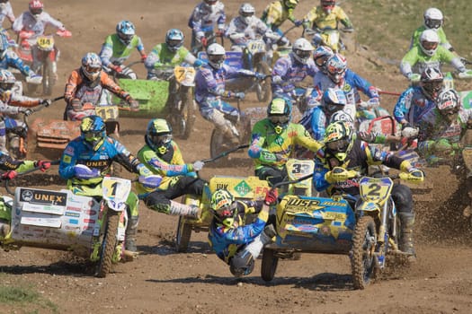 MOHELNICE, CZECH REPUBLIC - APRIL 25. Riders are entering the first turn after the start in "International Championship of Czech Republic in sidecarcross 2015"" on April 25. 2015 in Mohelnice."