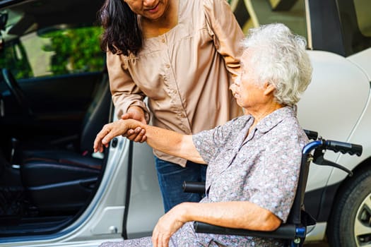 Caregiver help Asian elderly woman disability patient get in her car, medical concept.