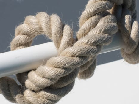 A thick rope entwined on the ship's rail.