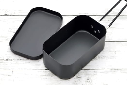 New camping tableware on a white painted wooden table