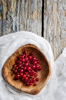 Red currant in the wooden bowl
