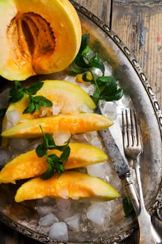 Melon slices on silver plate with mint