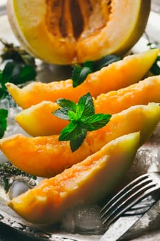 Melon slices on silver plate with mint