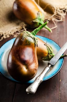 Fresh eggplants on rustic wooden table
