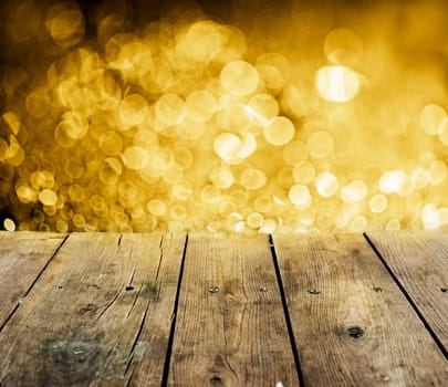 Empty wooden table with christmas lights behind.