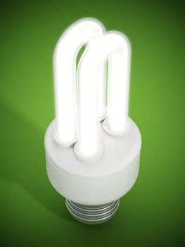 Fluorescent energy saving lightbulb on green surface.