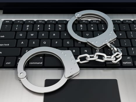 Handcuffs standing on laptop computer keyboard