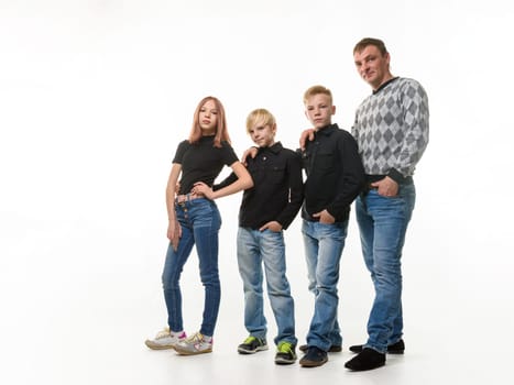 Dad, two sons and daughter in casual clothes in dark colors, full length portrait, white background