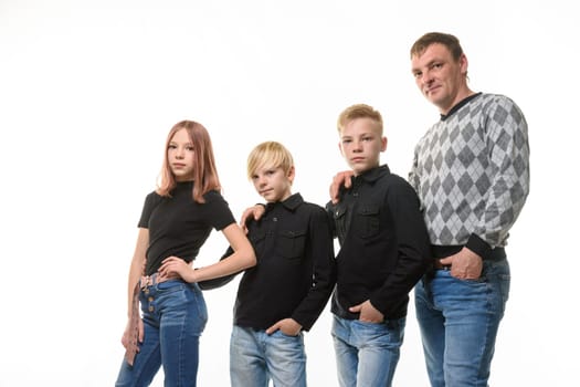 Dad, two sons and a daughter in casual clothes in dark colors, white background