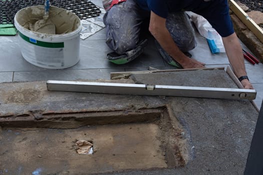 Laying ceramic floor tiles - man hands closeup
