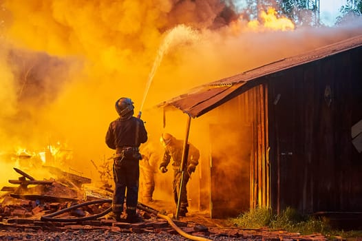 Firefighters extinguish a fire in a farm building. High quality photo