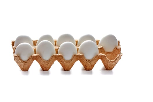 Nine white eggs on a cardboard stand on a white isolated background, copy space. High quality photo