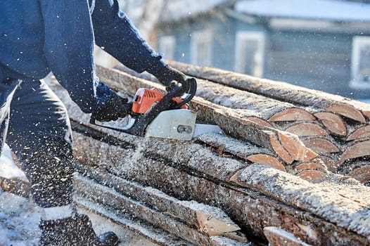 Sawing wood with a chainsaw for the furnace furnace in the fresh air. High quality photo