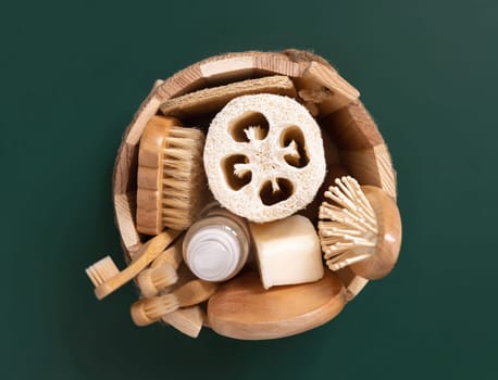 Sauna bucket with organic natural cosmetics and zero waste reusable accessories for skin and hair care on green. Top view of eco friendly beauty products for bath, massage or spa salon