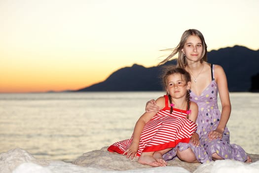 Two girls at the sea in the evening