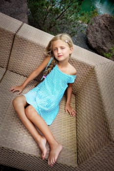 Beautiful girl relaxing on the wicker armchair I