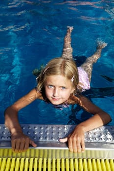 Blond girl swimming in pool