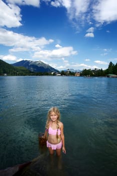 Little blonde girl swimming in the lake