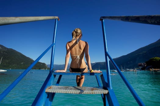 Woman sitting on the stairs to water
