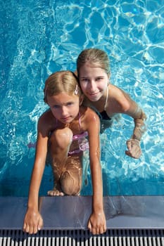Woman with girl swimming in pool