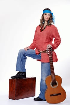Young hippie woman with suitcase and guitar