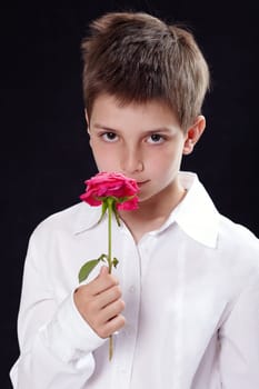 Portrait of a young boy smelling a rose