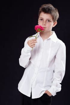Portrait of a young boy smelling a rose