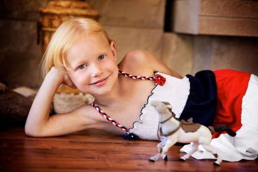 Portrait of a little girl playing with a horse