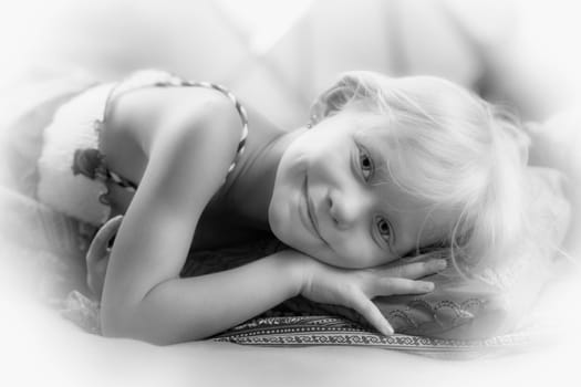 Portrait of a little girl lying on a pillow