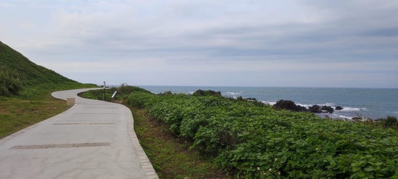 The Sea harbor with blue sky and green meadow.