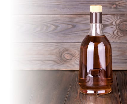 The Bottle of whiskey on a wooden background