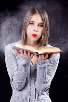 Woman blows dust out of the book II.