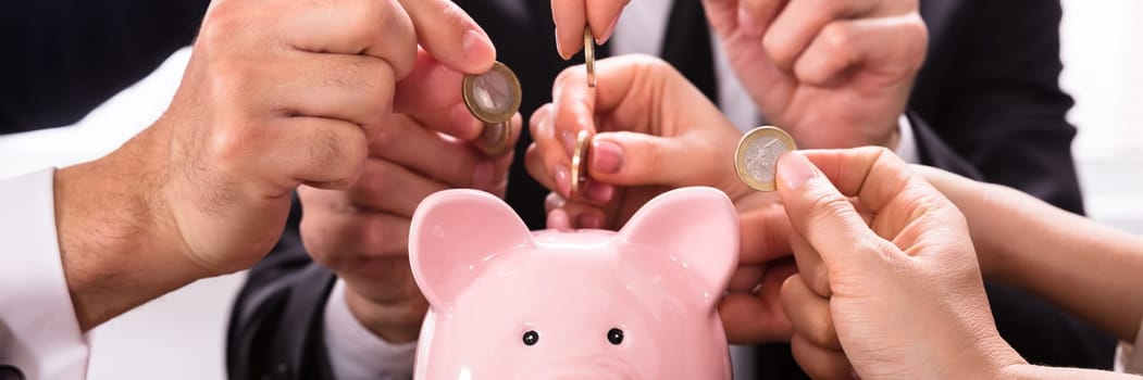 Crowdfunding Concept. People Inserting coins into piggybank
