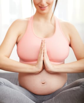 Pregnant woman doing yoga exercise relaxing with meditation.