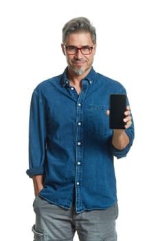 Happy older smart man in casual shirt and glasses smiling, showing phone with blank screen, ..isolated on white background.