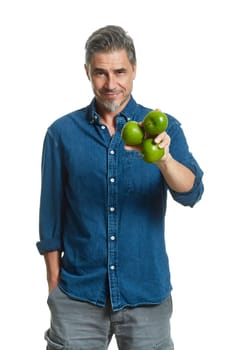 Casual older white man man holding green apple - healthy eating.