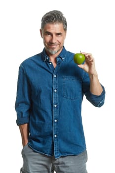 Casual older white man man holding green apple - healthy eating.