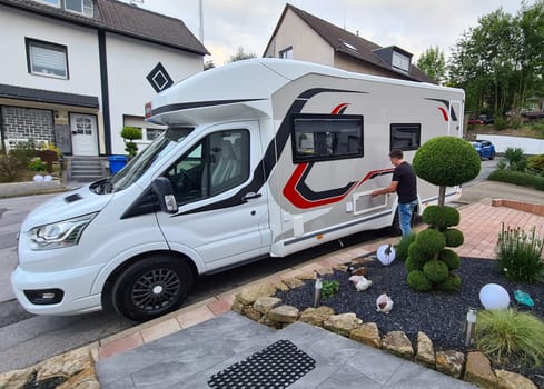 Man standing near motorhome getting ready to travel for family vacation travel, vacation trip in motorhome motorhome, caravan vacation.