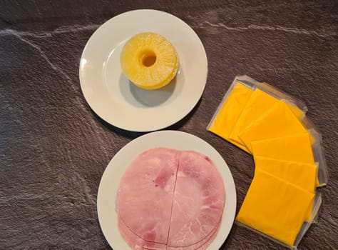Hawaiian toast with ham, cheese and pineapple on a cutting board on a dark background, horizontal