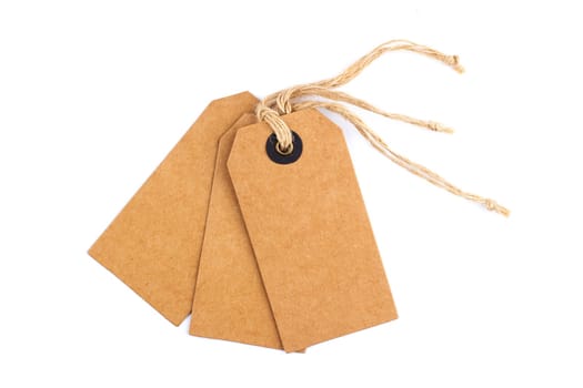 top view closeup of three vintage blank craft paper tags with textile thread isolated on white background