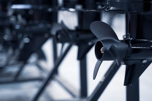 perspective view closeup of row of black boat ship propellers