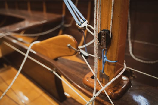 closeup of base of sailing yacht wooden mast with ropes tied around it