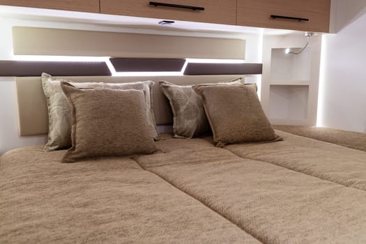 closeup of bed and pillows inside empty bedroom in luxury RV camper trailer interior