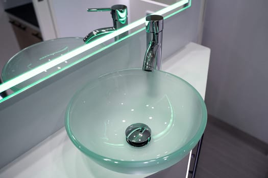 closeup of small toilet glass sink with mirror inside luxury RV camper trailer