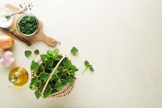 Nettle pesto for cooking healthy meal on grey background. Spring healthy food