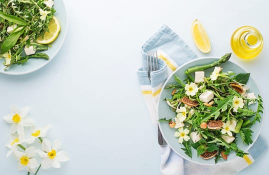 Spring salad with dandelion, asparagus, wild garlic, flowers, nettle and cream cheese. Healthy spring detox food background.