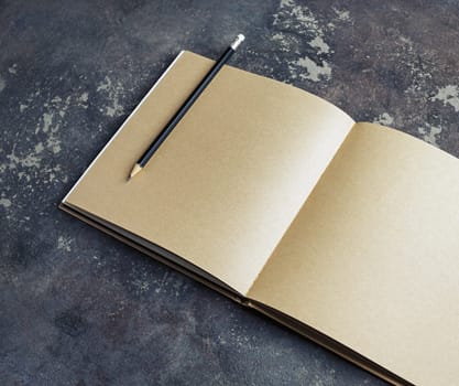 Blank vintage sketchbook and pencil on concrete background. Responsive design template.