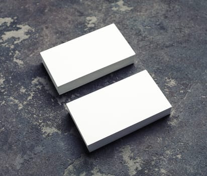 Photo of blank white business cards on concrete background. Template for ID. Mock up for for branding identity.
