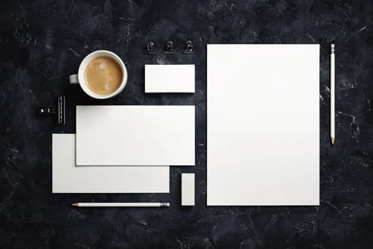 Photo of blank corporate stationery set on black plaster background. Template for branding design. Top view. Flat lay.